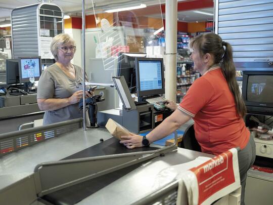 Lillian Svenning (t.v.) er takknemlig for å kunne hente medisinene sine på nærbutikken på Stokkøya. Butikkmedarbeider Nadja Luyten ser på det som en viktig del av butikkens totale servicetilbud. Foto: Kristin Rosmo